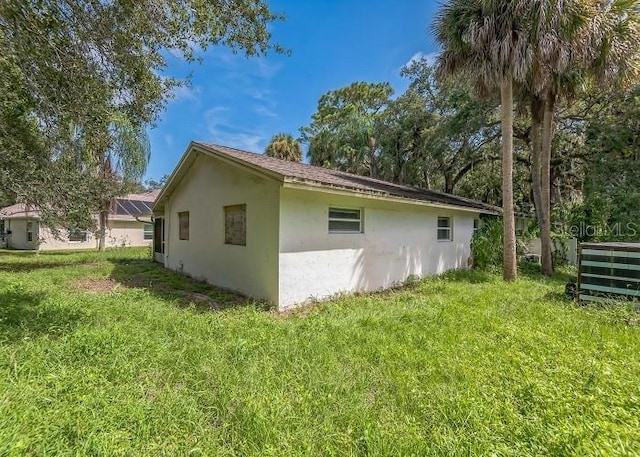 view of property exterior with stucco siding and a yard