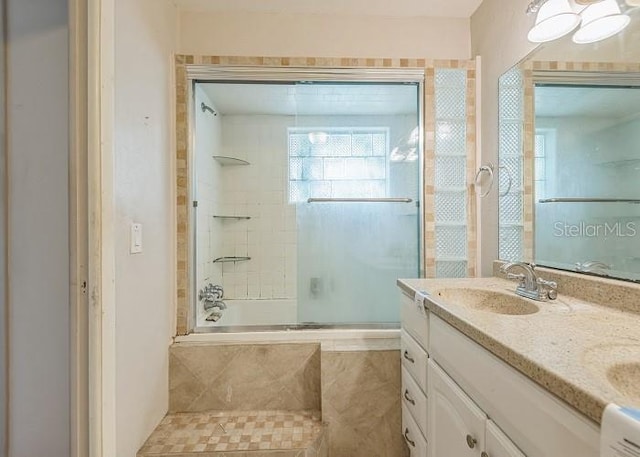 full bath featuring tiled shower / bath, double vanity, and a sink