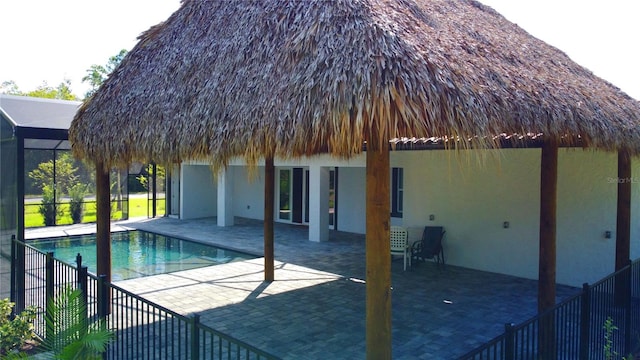 view of swimming pool with a gazebo, glass enclosure, and a patio area