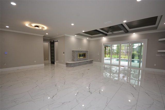 unfurnished living room featuring beamed ceiling, a raised ceiling, crown molding, a high end fireplace, and a barn door