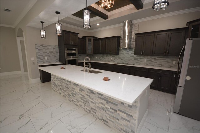 kitchen featuring fridge, beam ceiling, sink, an island with sink, and double oven