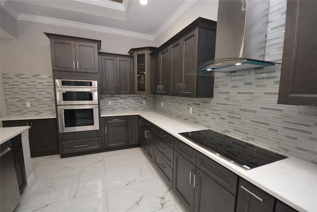 kitchen featuring wall chimney range hood, crown molding, dark brown cabinets, decorative backsplash, and double oven