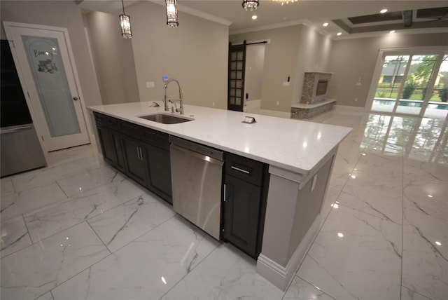 kitchen featuring a barn door, a center island with sink, sink, dishwasher, and hanging light fixtures