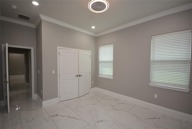 unfurnished bedroom with ornamental molding, multiple windows, and a closet