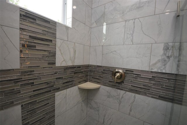 bathroom with walk in shower and tile walls