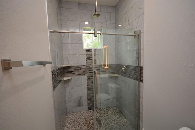 bathroom with a shower with door