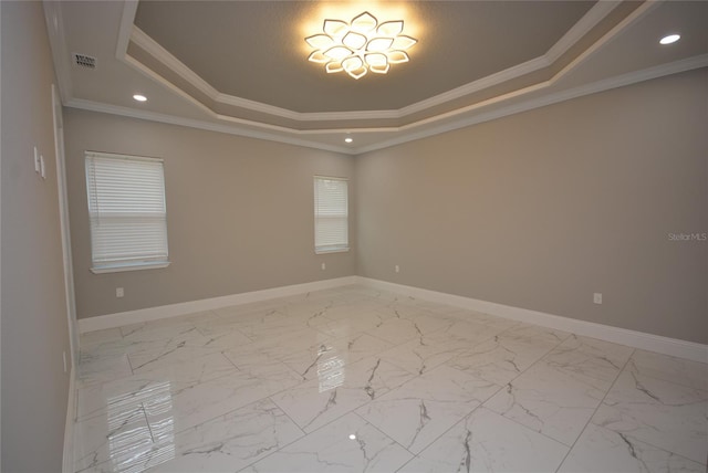 spare room featuring a raised ceiling and ornamental molding