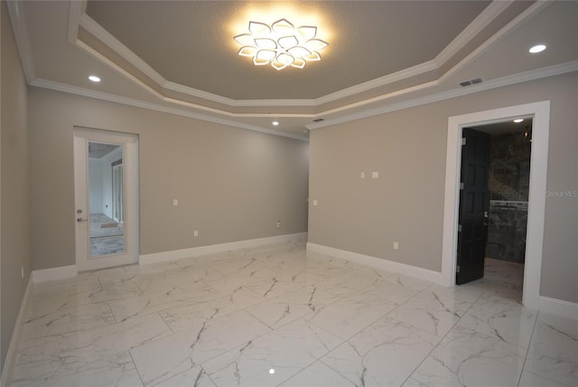 empty room featuring ornamental molding and a raised ceiling