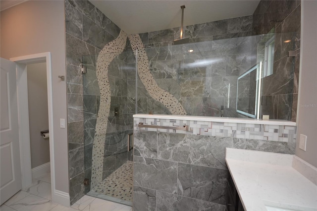 bathroom featuring a tile shower and vanity