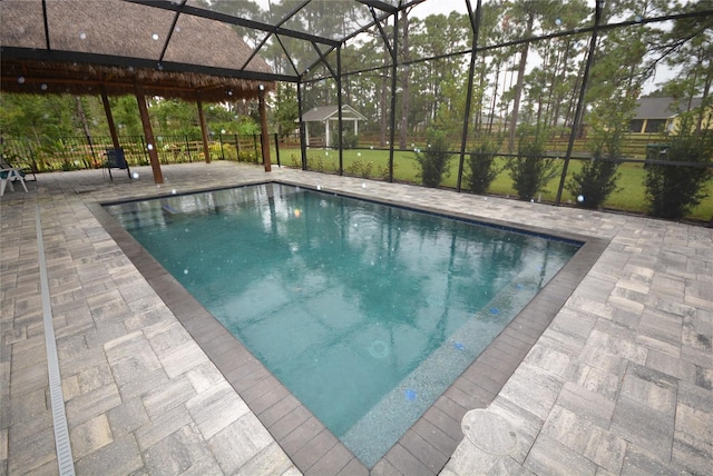 view of pool featuring glass enclosure and a patio