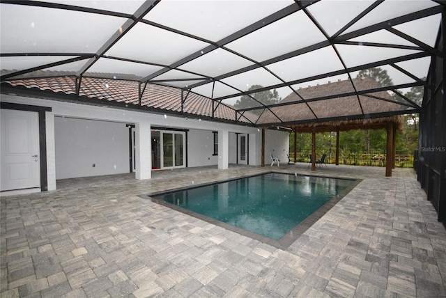 view of swimming pool with glass enclosure and a patio area