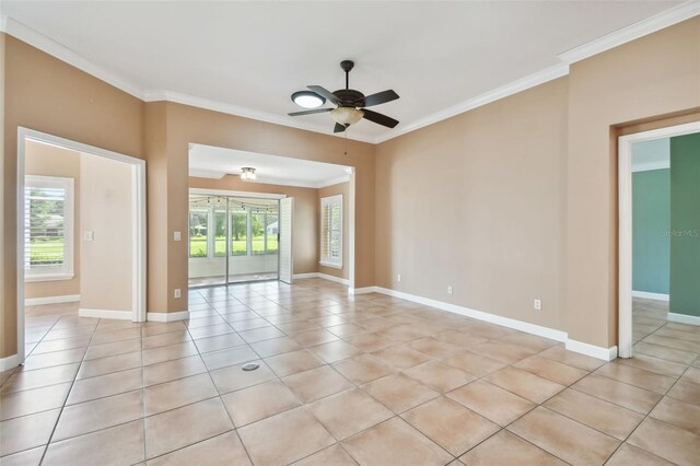 spare room with ceiling fan, light tile patterned floors, and ornamental molding