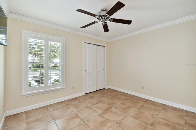 unfurnished bedroom featuring ornamental molding, ceiling fan, a closet, and light tile patterned floors