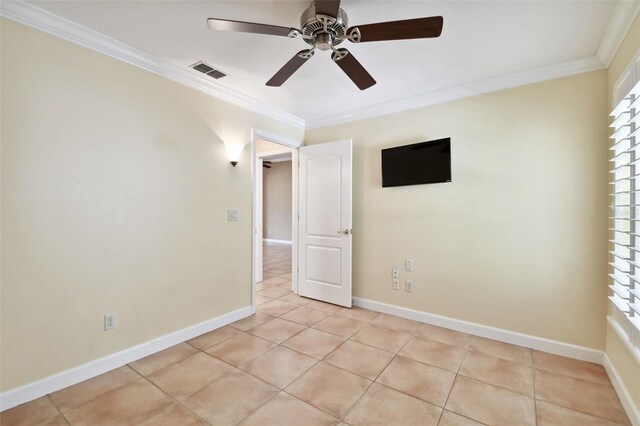 unfurnished room featuring ceiling fan, crown molding, and light tile patterned floors