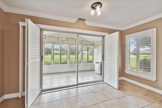 doorway with light tile patterned flooring, crown molding, and a textured ceiling