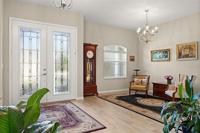 foyer with an inviting chandelier, hardwood / wood-style floors, and french doors