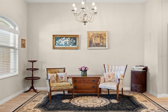 living area featuring a notable chandelier and light wood-type flooring