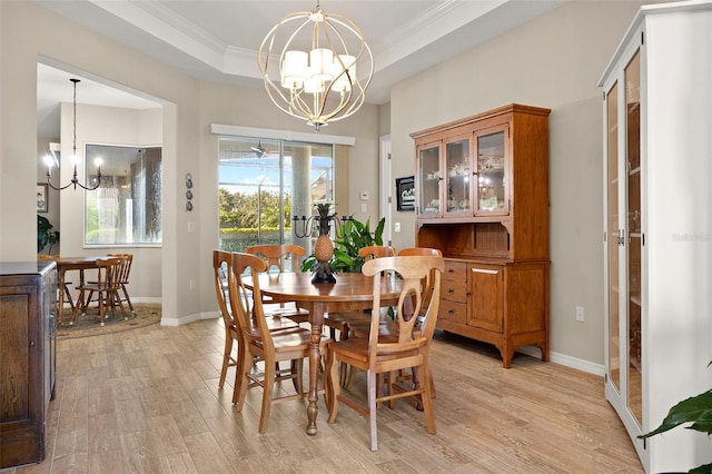 dining room featuring a tray ceiling, light hardwood / wood-style flooring, french doors, ornamental molding, and a chandelier