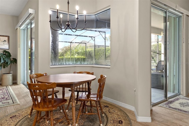 dining area featuring light hardwood / wood-style floors and an inviting chandelier