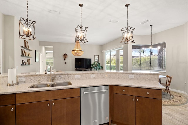 kitchen featuring dishwasher, pendant lighting, light stone countertops, light hardwood / wood-style flooring, and sink