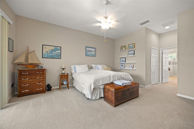 bedroom with connected bathroom, ceiling fan, light colored carpet, and a closet