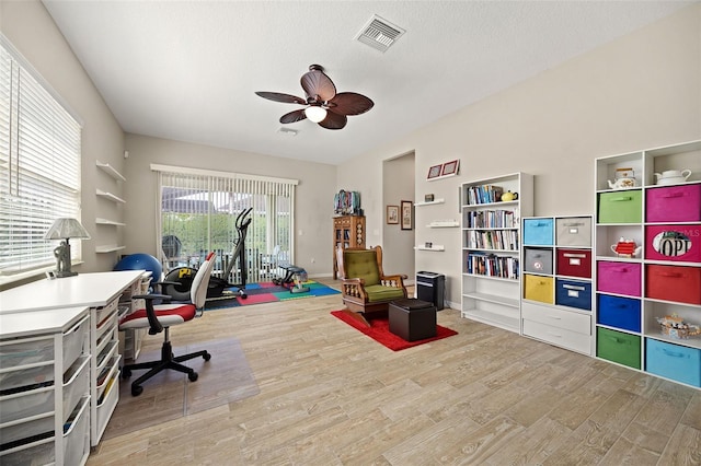 home office featuring wood-type flooring, a textured ceiling, and ceiling fan