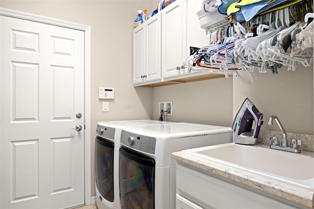 laundry area featuring washer and clothes dryer, sink, and cabinets