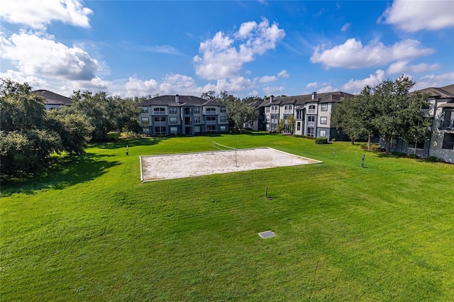 view of community with a lawn and volleyball court