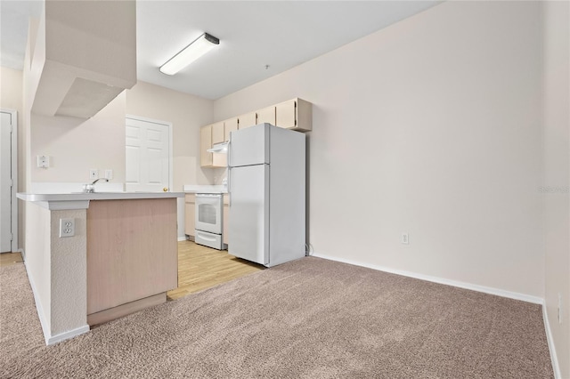 kitchen featuring sink, light carpet, kitchen peninsula, and white appliances