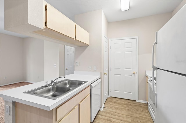 kitchen featuring kitchen peninsula, sink, light wood-type flooring, and white appliances