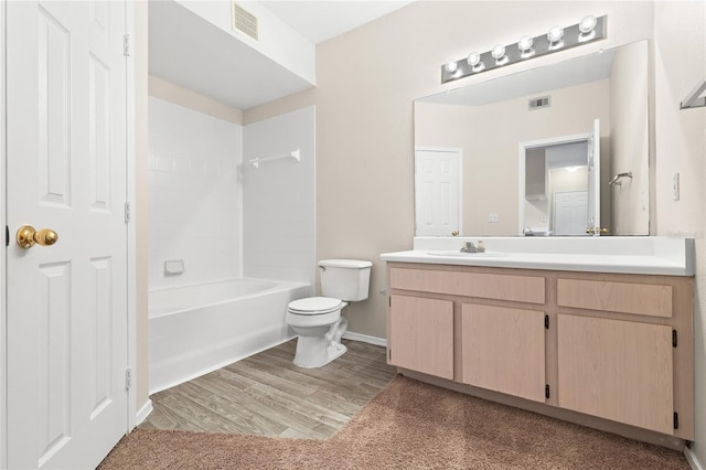 full bathroom with toilet, hardwood / wood-style flooring, vanity, and washtub / shower combination