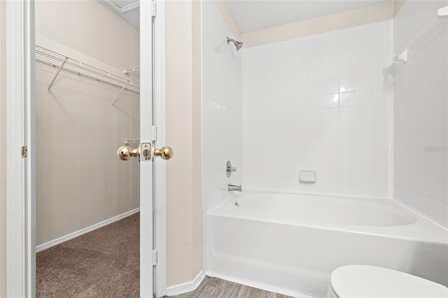 bathroom featuring toilet, hardwood / wood-style flooring, and tiled shower / bath