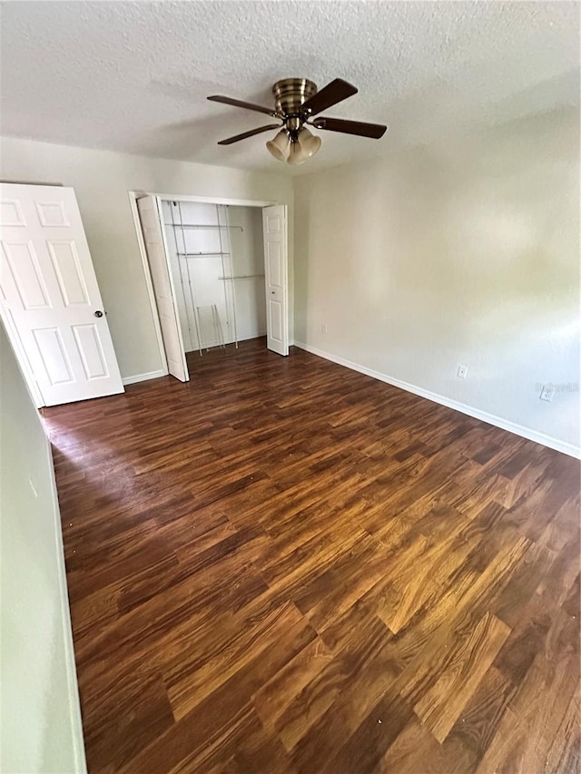 unfurnished bedroom with a closet, ceiling fan, dark hardwood / wood-style flooring, and a textured ceiling