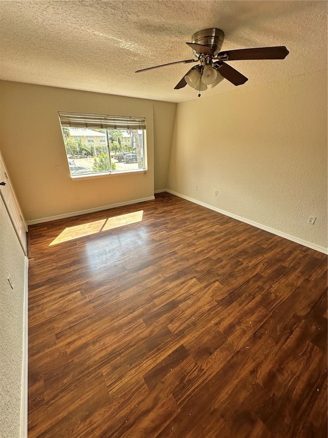 empty room with a textured ceiling, ceiling fan, and dark wood-type flooring