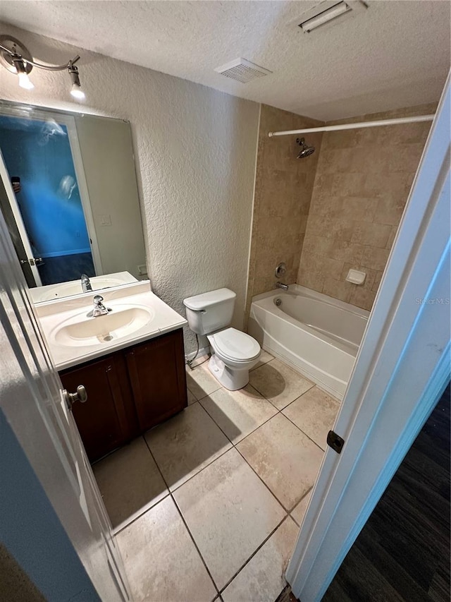 full bathroom featuring tile patterned flooring, vanity, a textured ceiling, and toilet