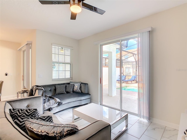 living room featuring ceiling fan and a healthy amount of sunlight