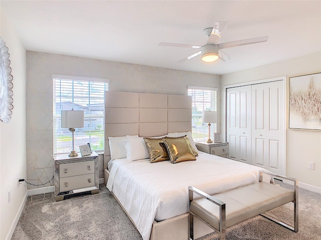 carpeted bedroom with ceiling fan, a closet, and multiple windows