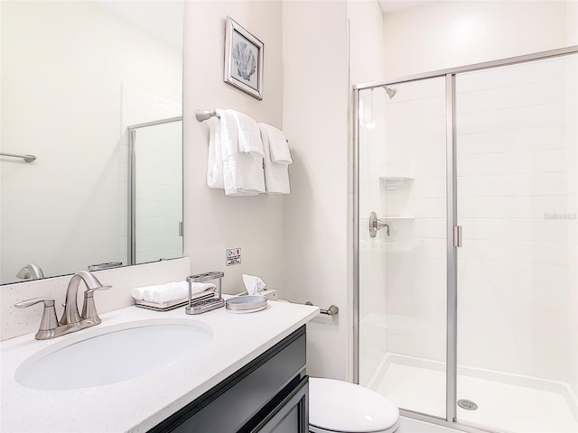 bathroom featuring walk in shower, vanity, and toilet