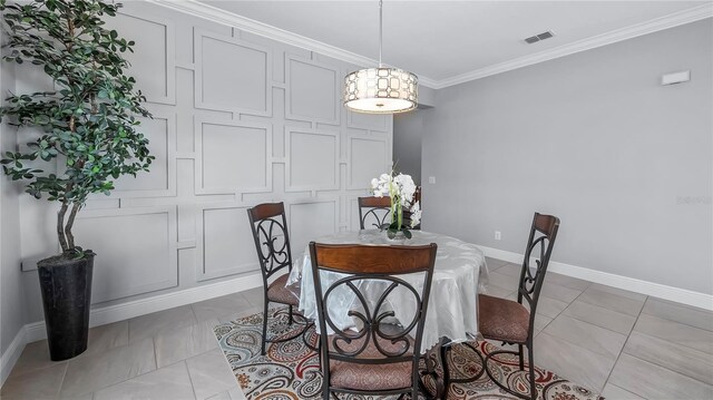 tiled dining space featuring ornamental molding