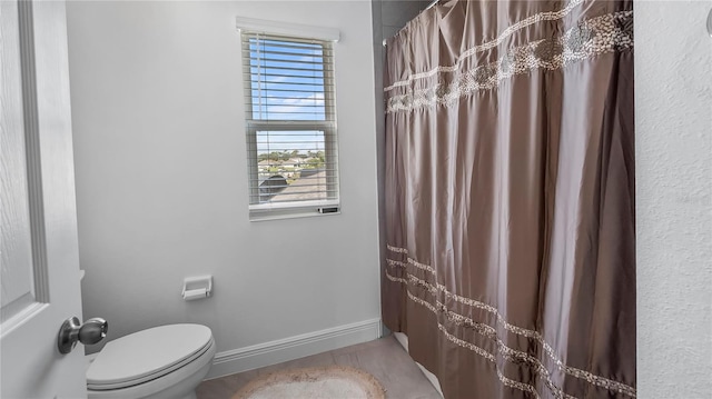 bathroom featuring a healthy amount of sunlight, a shower with curtain, and toilet