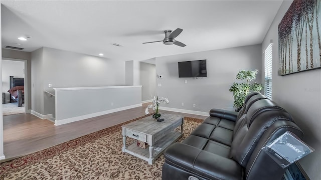 living room featuring wood-type flooring and ceiling fan