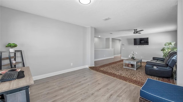 living room featuring ceiling fan and wood-type flooring