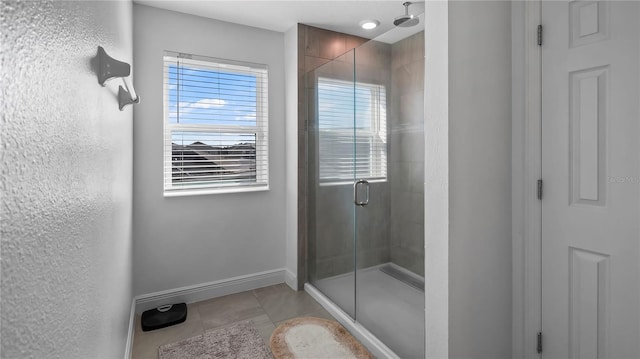 bathroom with a shower with door and tile patterned flooring