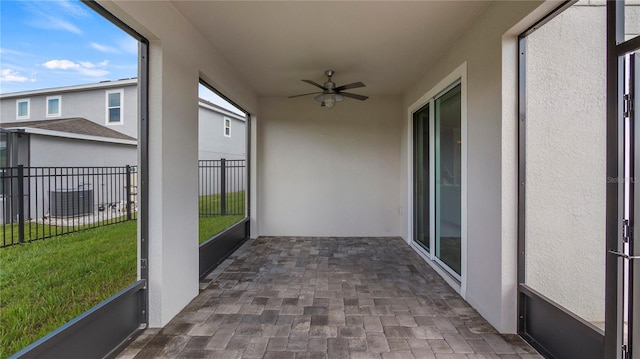 unfurnished sunroom with ceiling fan