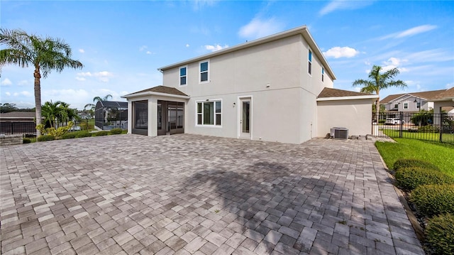 back of property with a yard, a patio area, and central AC unit