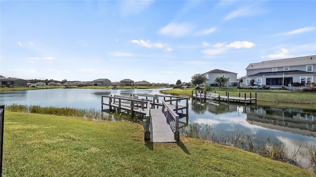 dock area featuring a lawn and a water view