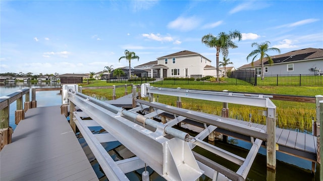 dock area featuring a water view and a lawn