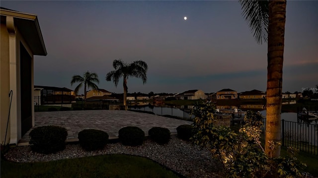 yard at dusk featuring a water view