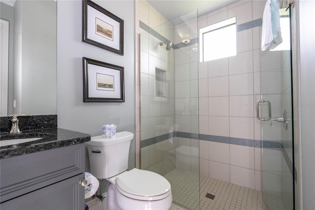 bathroom featuring vanity, tile patterned flooring, toilet, and an enclosed shower