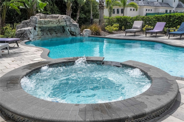 view of swimming pool with a patio area, an in ground hot tub, and pool water feature